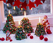 Christmas tree candles with artificial snow as windowsill decoration