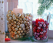 Candles in large glasses with Christmas tree balls