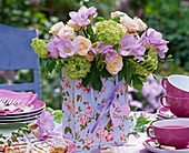 Bouquet of Rose, freesia, viburnum in paper bag