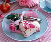 Rosa (Rose), Petit-Four in Herzform, pinkfarbene Serviette