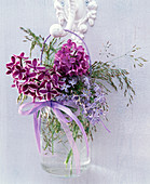 Small bouquet of different Syringa, and grasses in handle glass