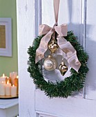 Door wreath made of fir with tree ornaments and bow