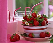 Bowl with fresh strawberries and strawberry milkshake