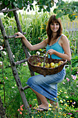 Junge Frau mit Korb mit frisch gepflückten Malus (Äpfeln)