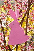 Easter bunny made of pink felt hung on Prunus (ornamental cherry)