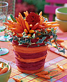 Arrangement of ornamental paprika in cachepot from bast