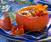 Kürbissuppe in Cucurbita (Kürbis) dekoriert mit Tropaeolum (Kapuzinerkresse)