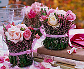 Small bouquets of roses in vase wrapped with Calluna