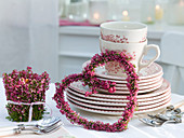 Heart of Erica (bell heather) leaning against a pile of dishes, lantern