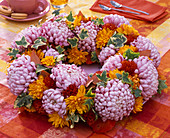 Wreath of chrysanthemum, hedera and autumn leaves