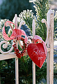 Kleiner Kranz aus Hagebutten, rotes Herz mit Aufschrift 'Willkommen' am Zaun