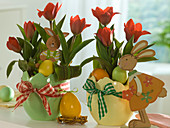 Tulipa 'Showwinner' (tulips) with wooden rabbits and Easter eggs in Easter planters