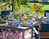 Table decoration with white easter bunnies in pots with Carex, bouquet