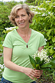 Woman with bouquet of Convallaria majalis (Lily of the Valley)