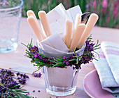 Kranz aus Lavandula (Lavendel) um Glas mit Serviette und Besteck