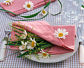 Serviettendekoration mit Leucanthemum (Frühlings - Margeriten) und Gräsern