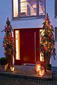 Red front door decorated for Christmas