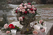 Arrangement of pink (roses) and Christmas tree balls in a stone vase
