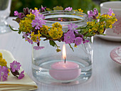 Glass as a lantern with floating candle and a Silene dioica wreath