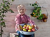 Boy with enamelled bowl of 'Cox Orange' apples