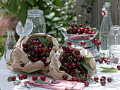 Bags of sour cherries (Prunus cerasus), preserving jars, bottles, scales