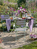 Gedeckter Tisch auf Kiesfläche im Garten