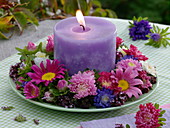 Violette Kerze im Spätsommerkranz