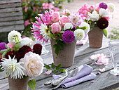 Table decoration with dahlias and roses in terracotta vases