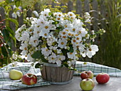 White autumnal bouquet in wooden containers on a table