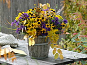 Autumn bouquet of perennials in a wooden barrel