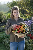 Young woman holding chip basket with peppers and paprika