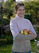 Junge Frau hält Äpfel im Arm