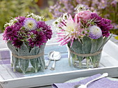 Glasvasen mit Stachysblättern umwickelt mit Herbststräußen