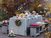 Autumn-covered table with roses and chrysanthemums bouquets