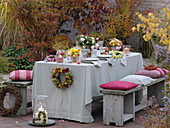 Autumn table with bouquets of roses and chrysanthemums