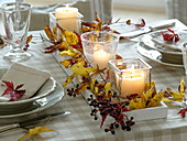 Fast, autumnal table decoration with red and yellow autumn leaves