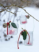 Jam jars hung as lanterns on a branch with wire