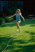 HAZEL PLAYING with A HOSEPIPE IN THE GARDEN. THE NICHOLS Garden, READING