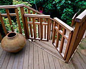 DECKED TERRACE AND BALCONY with CHILD SAFE GATE AND TERRACOTTA URN. Designer: Sarah LAYTON