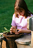 Designer: Clare MATTHEWS - HANGING VEGETABLE Garden - Girl PLANTING CUCUMIS
