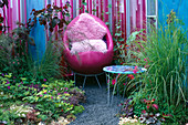 Ein Platz zum Sitzen: rosa, mit Flüssigkeit gefüllte Wände, rosa Stuhl und rosa Kissen