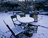 Verschneite Sitzgruppe im winterlichen Garten