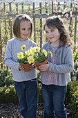 Girl in the cottage garden with pansies