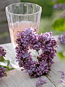 Small heart of Syringa (lilac) leaning against glass