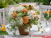Orange-white table decoration with dahlias