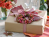Gift decorated in autumn with wreath of pink (rose hips)