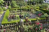 Künstlergarten : Gartenzaun mit Fuchsien und getöpferten Kunstobjekten