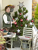 Woman decorating Pinus (pine) for Christmas