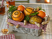 Kleiner Korb mit Pomander und Mandarinen (Citrus), Erdnüssen