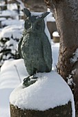 Verschneite Eule aus Bronce auf Steinsäule